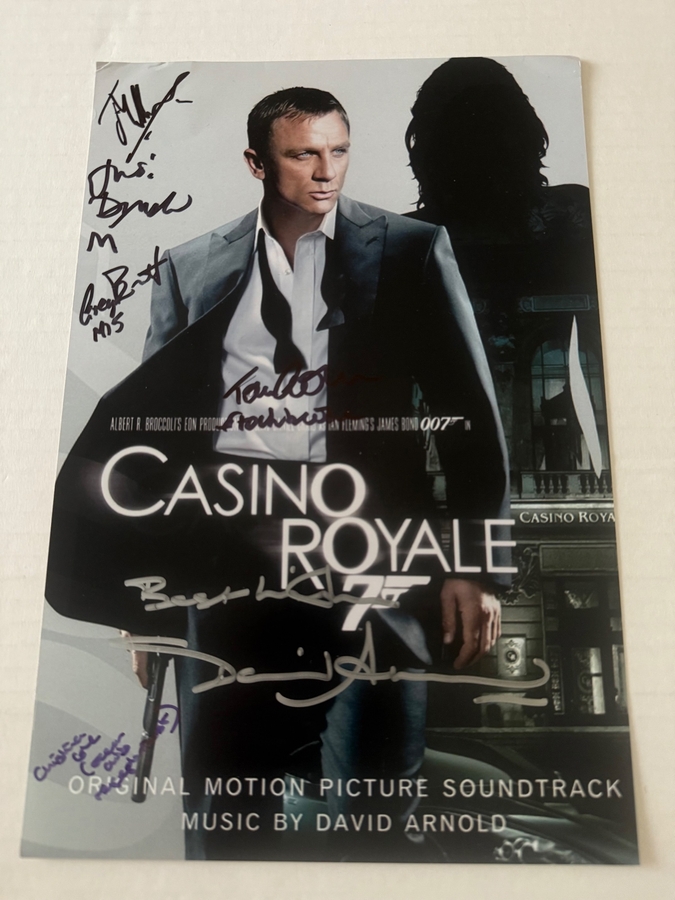 Casino Royale photo signed by David Arnold, Judi Dench, Christina Cole, Tom Chadbon, Greg Bennett and Joseph Millson