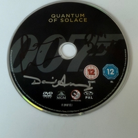 Quantum of Solace DVD disc, signed by Judi Dench, David Arnold  and one other. Disc only