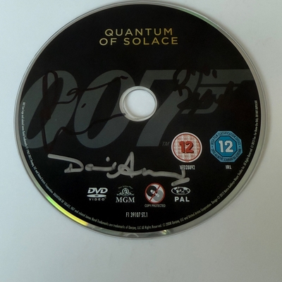 Quantum of Solace DVD disc, signed by Judi Dench, David Arnold  and one other. Disc only