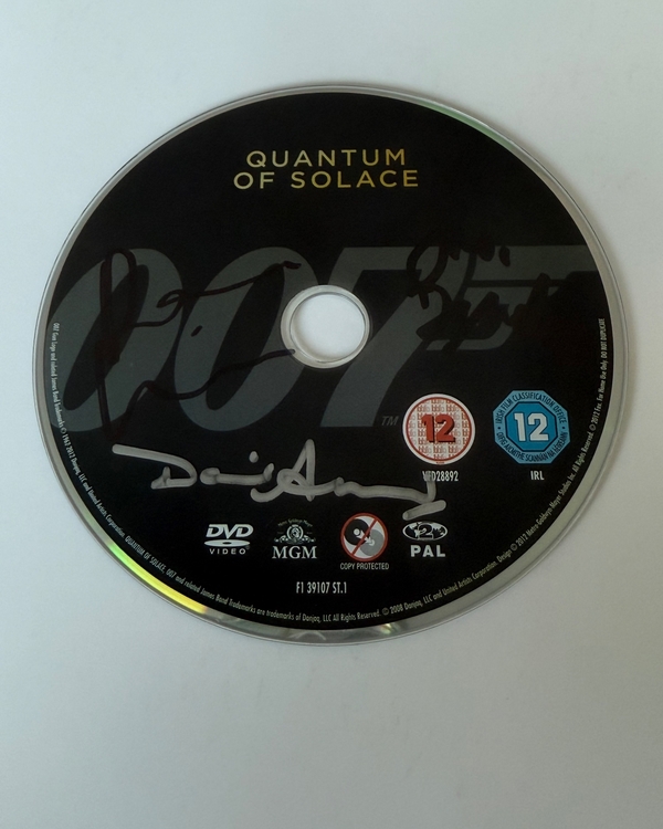 Quantum of Solace DVD disc, signed by Judi Dench, David Arnold  and one other. Disc only