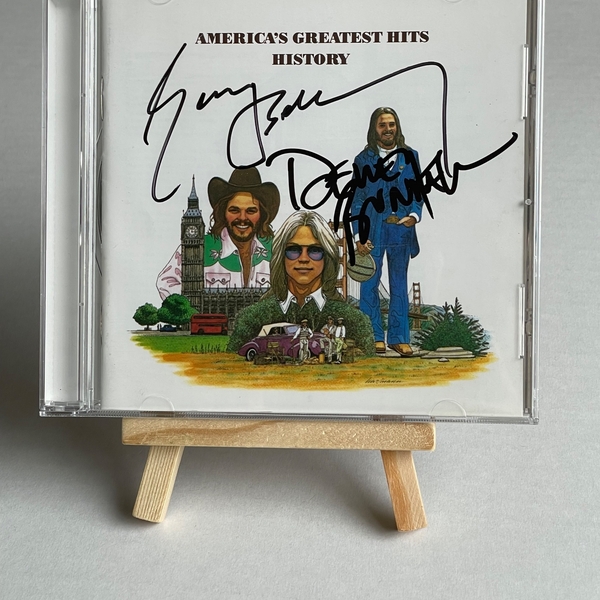 America - America’s Greatest Hits History CD. Signed by Dewey Bunnell and Gerry Beckley