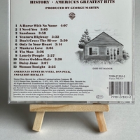 America - America’s Greatest Hits History CD. Signed by Dewey Bunnell and Gerry Beckley