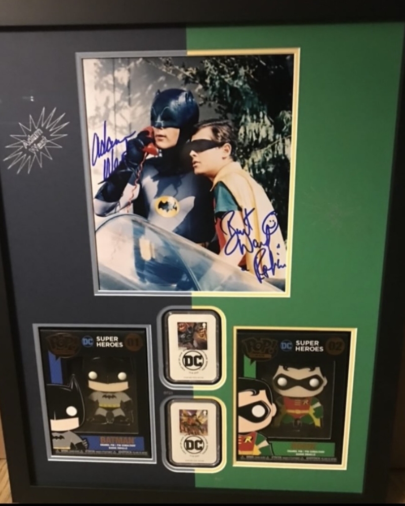Burt ward & Adam West joint signed picture with2 funko badges and 2 Batman themed 1st stamps. Professionally mounted and framed signed item